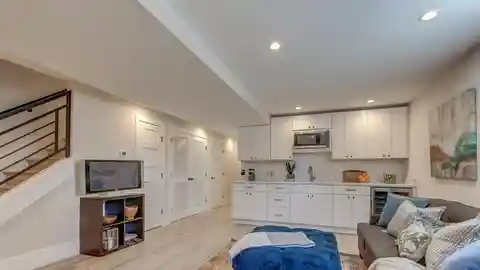 Finished basement suite with pot lights, vinyl flooring, and neutral walls
