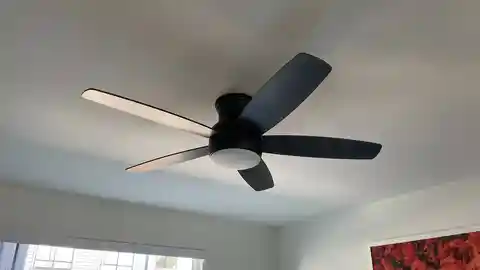 Matte black five-blade ceiling fan with LED light in bedroom