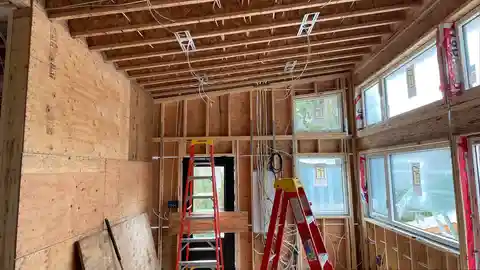 Custom home electrical rough-in with exposed framing and pot light brackets