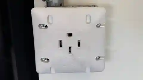 White NEMA 14-50 240V outlet mounted on wall for EV charging