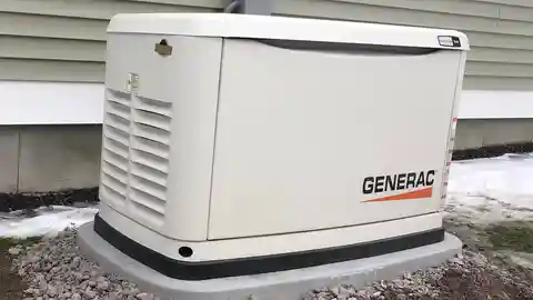 White Generac standby generator on concrete pad beside home in winter