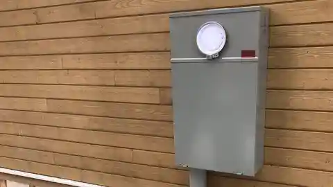 Gray 400-amp meter base mounted on natural wood siding