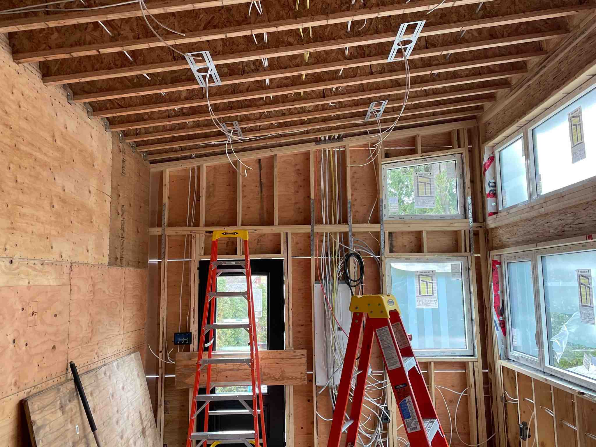 Custom home electrical rough-in with exposed framing and pot light brackets