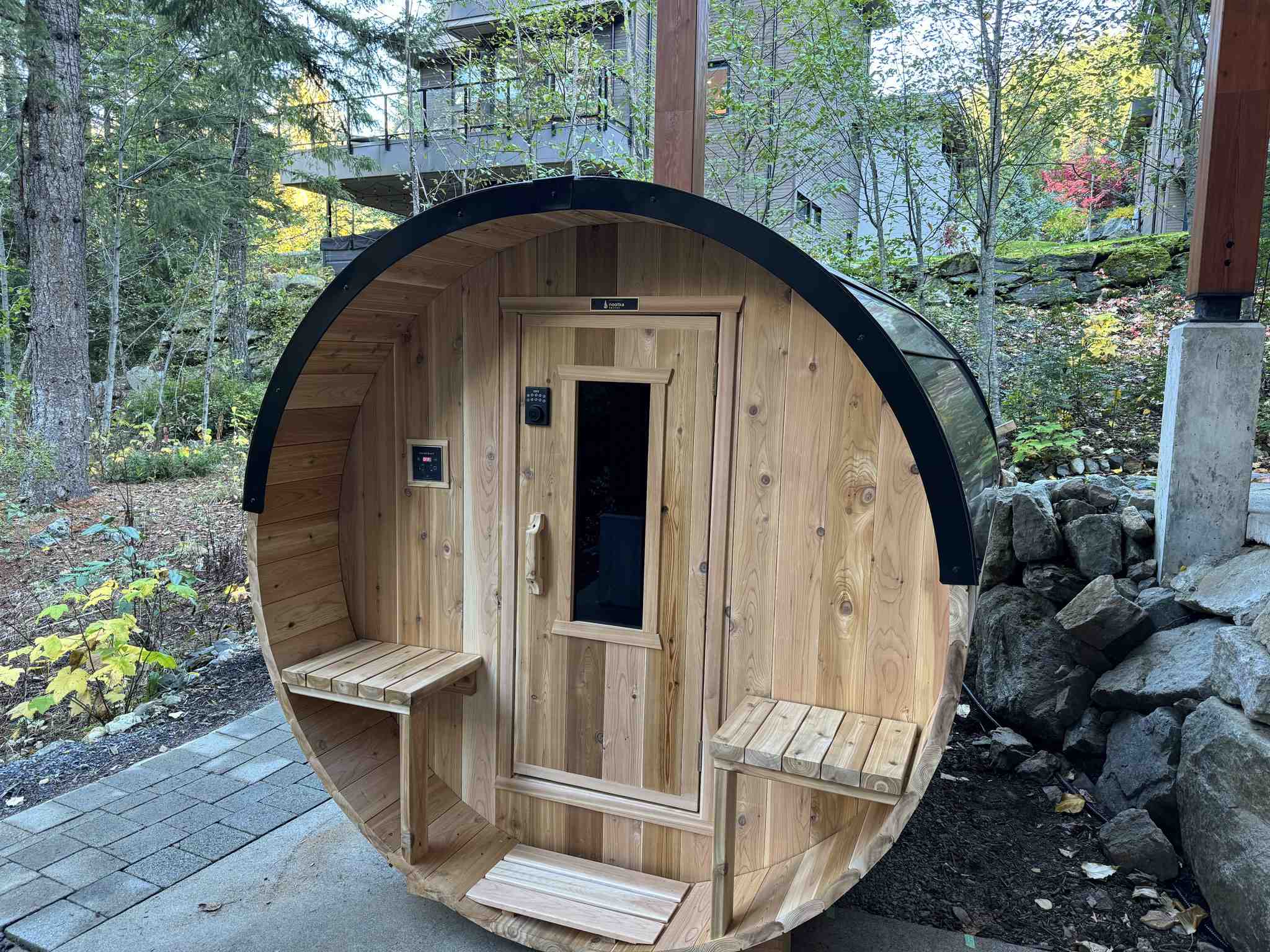 Nootka barrel sauna on stone base surrounded by Vancouver forest