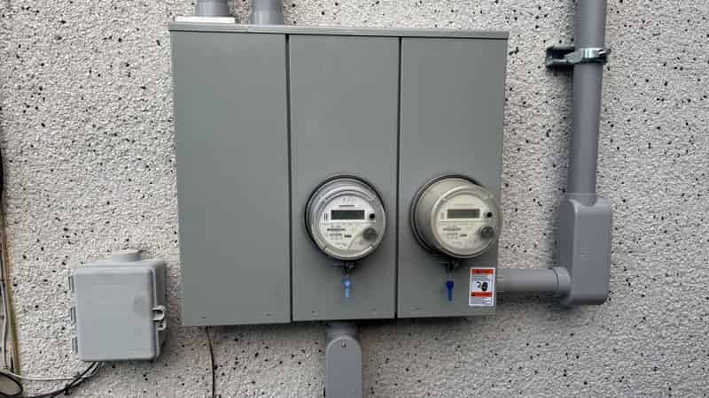 Dual electrical meters and service panel on exterior wall